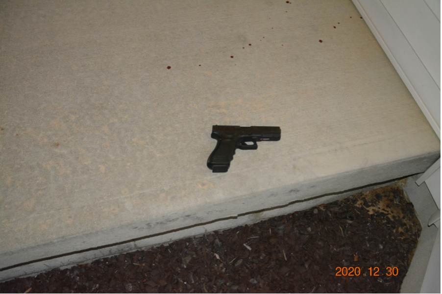 Photo showing firearm on the front porch of the nearby residence where Cochran was located.