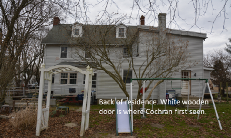 Back of residence. White wooden door is where Cochran was first seen.