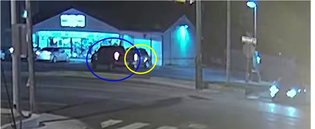 Figure 3. Still shot captured from surveillance footage of a business located across the street from the South Maryland Avenue 7-Eleven. Depicted in the footage is the undercover Ford pickup truck (circled in blue) as it attempts to conduct the “pinch” maneuver to block the path of escape for Edelmann’s Hyundai SUV (circled in yellow). 